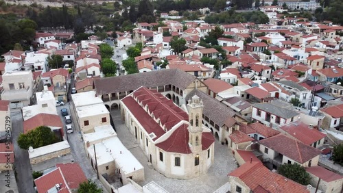 Aerial drone footage of traditional countryside valley village Omodos, in Limassol, Cyprus. 360 view of Timios Stavros (Holy Cross) monastery, tiled roof architecture and narrow streets from above.
 photo