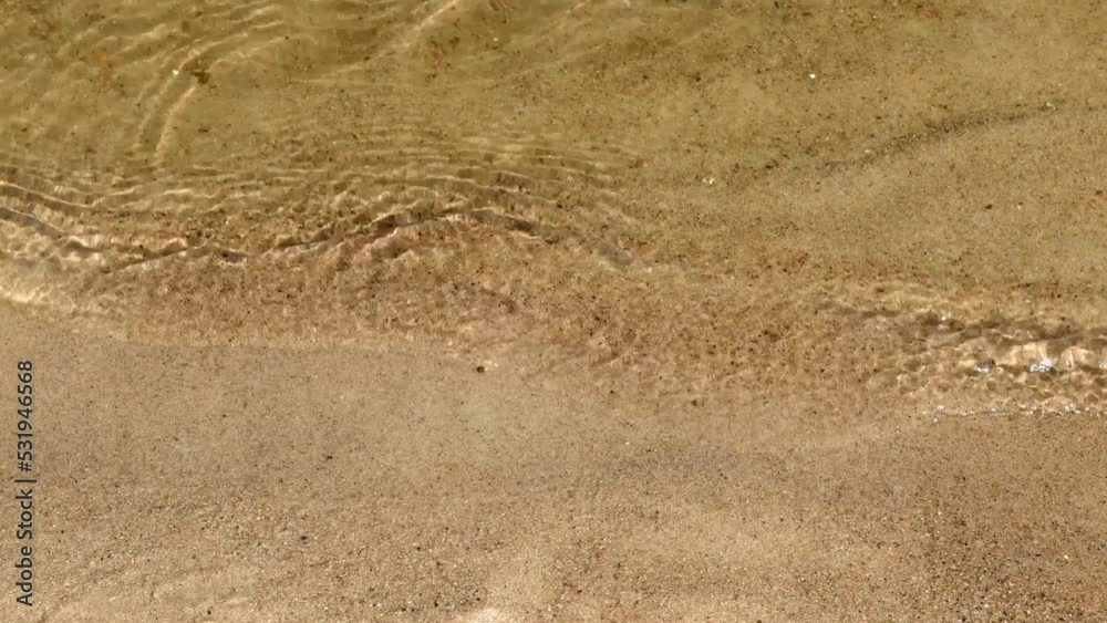 Close-up of calm river waves on a sandy beach. Crystal clear water. Close-up of calm river waves on a sandy beach. Crystal clear water.