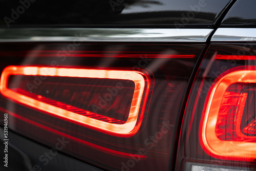 Modern car headlight of a black luxury car close up