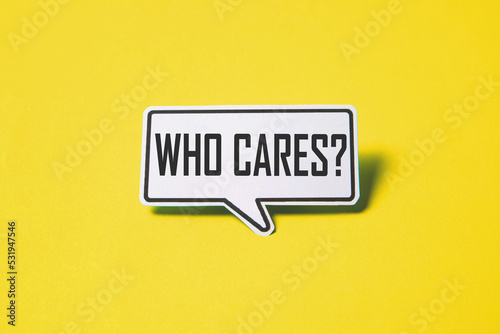 Who cares speech bubble on white paper isolated on yellow paper background with drop shadow.