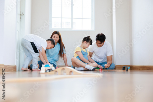 Happy asian family playing wood block create rail road  together at home