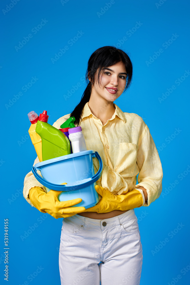woman in gloves holding bucket with cleaning supplies woman in gloves holding bucket with cleaning supplies