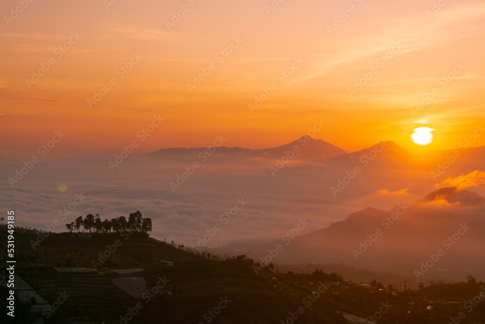 Sunrise over mountain with view of village on the slope of Mountain. Mangli Village on the slope of Sumbing Mountain