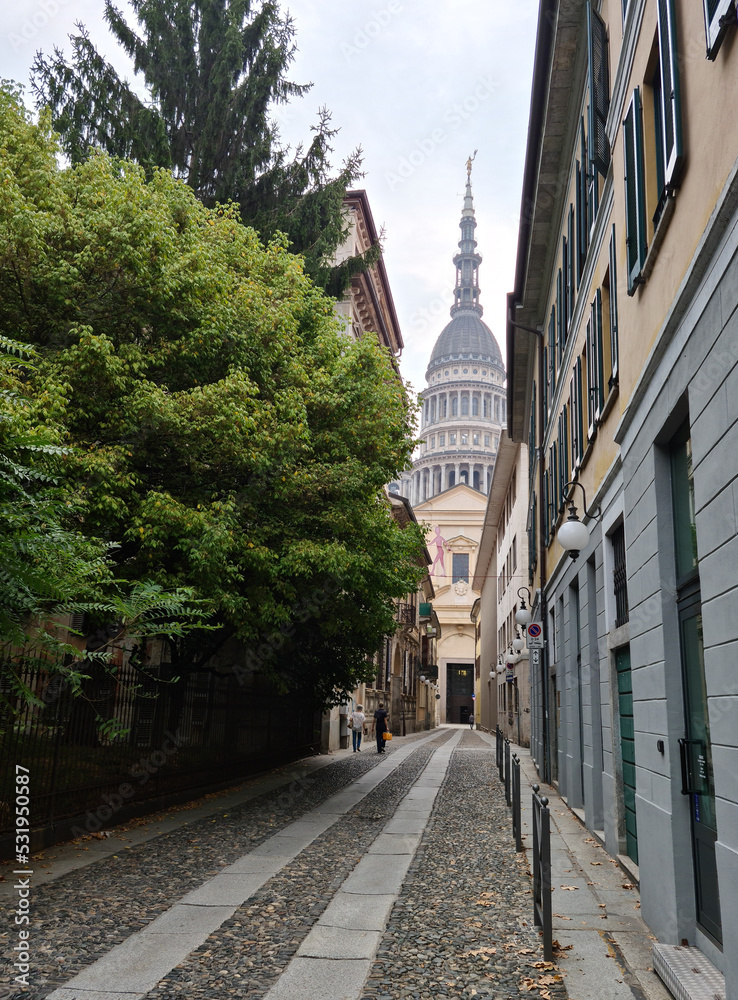 The stone-paved alleys of Novara under the grandeur of the dome of San Gaudenzio designed by Antonelli.
