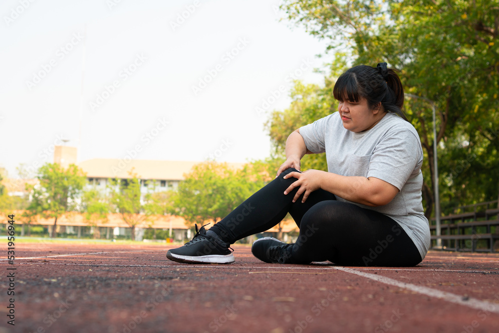 Fototapeta premium Asian overweight woman a new runner pain ankle during running, Athlete runner training accident. Sport running ankle sprained sprain cause injury. weight loss, workout, sports, health care concepts