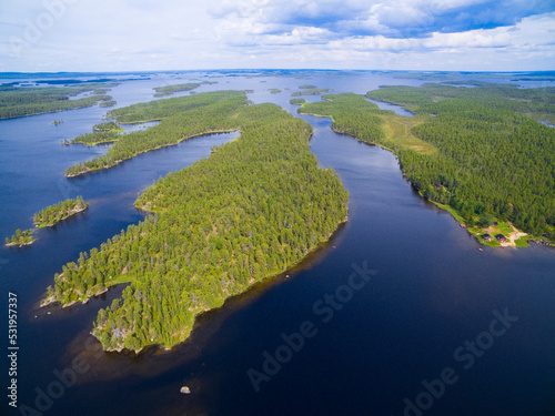 Aerial view of islands and traditional wooden houses on shore of Inari lake, Finland