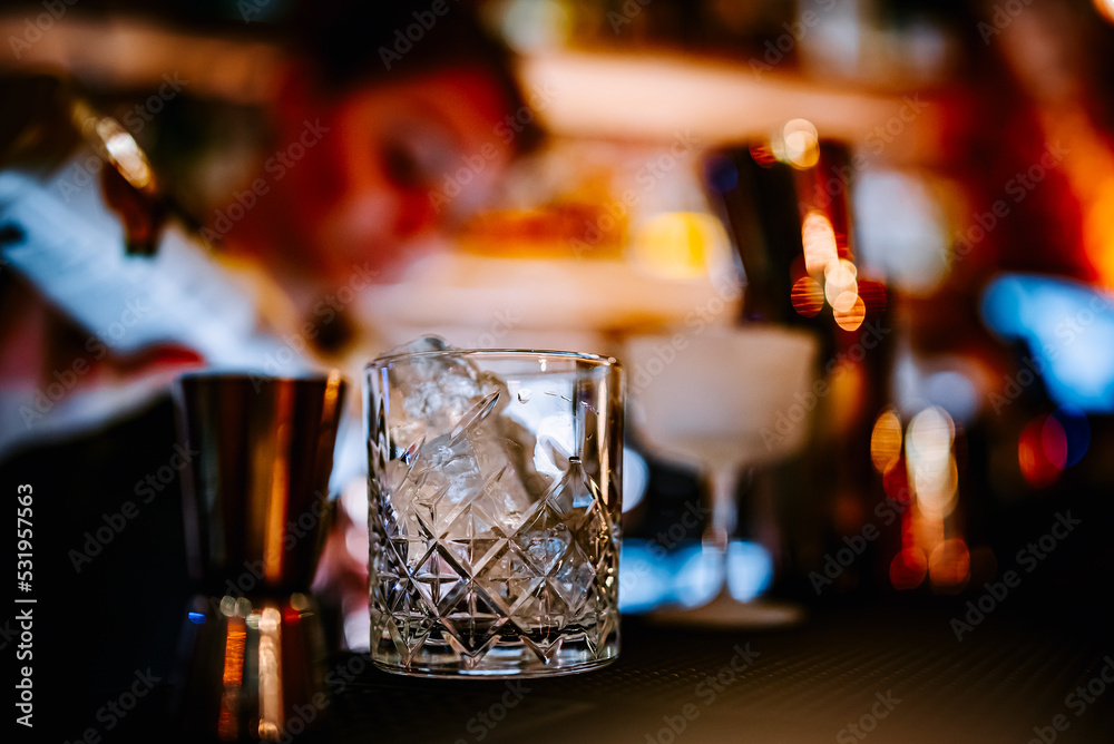Ice cube in an empty glass on a bar counter in bar or pub