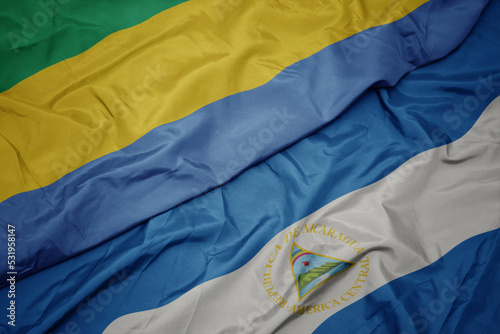 waving colorful flag of gabon and national flag of nicaragua. 3d illustration photo