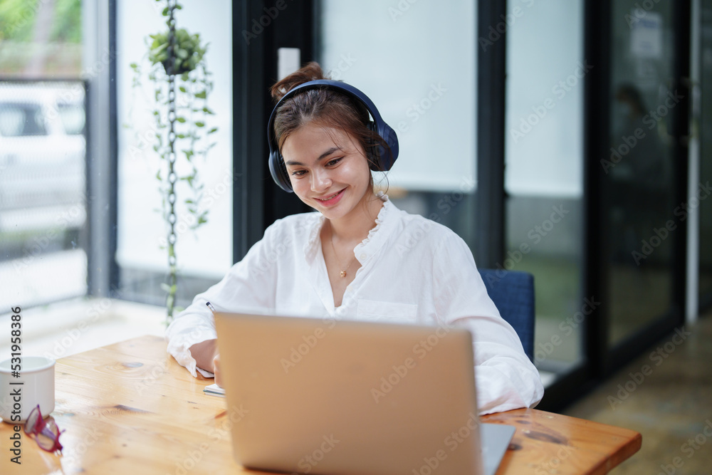 Fototapeta premium woman using a computer and earphone during a video conference