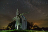 The ghost of the old mill. Old windmill at night with starry sky.