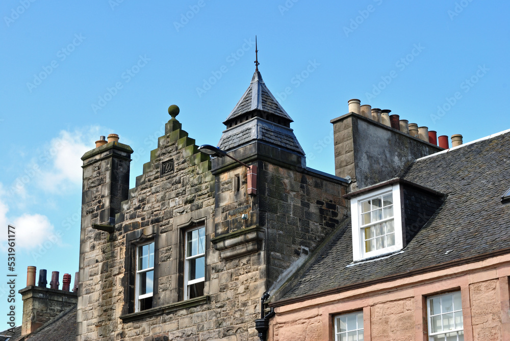 Old Stone Building with Chimneys seen against Blue Sky 