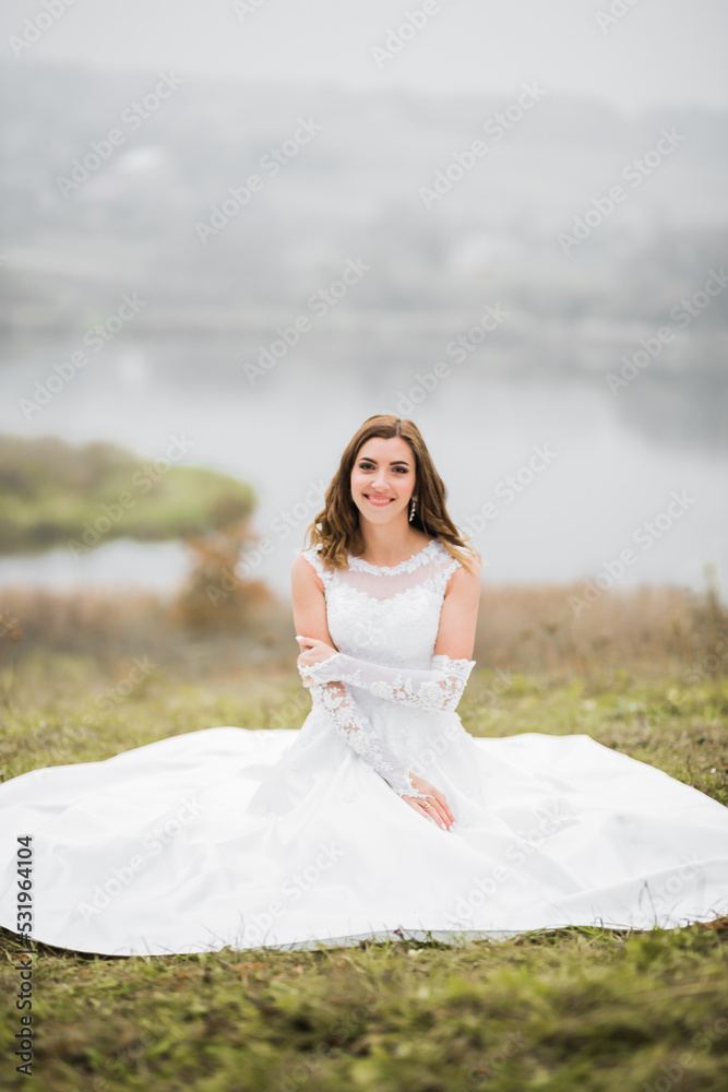 Beauty portrait of bride wearing fashion wedding dress with feathers with luxury delight make-up and hairstyle Beauty portrait of bride wearing fashion wedding dress with feathers with luxury delight make-up and hairstyle