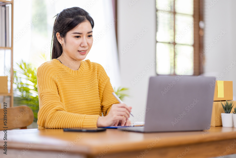 Business Asian women working on laptop computer checking customer order online shipping box at home. Starting Small business entrepreneur SME freelance. Online business, Work at home SME concept. Business Asian women working on laptop computer checking customer order online shipping box at home. Starting Small business entrepreneur SME freelance. Online business, Work at home SME concept.