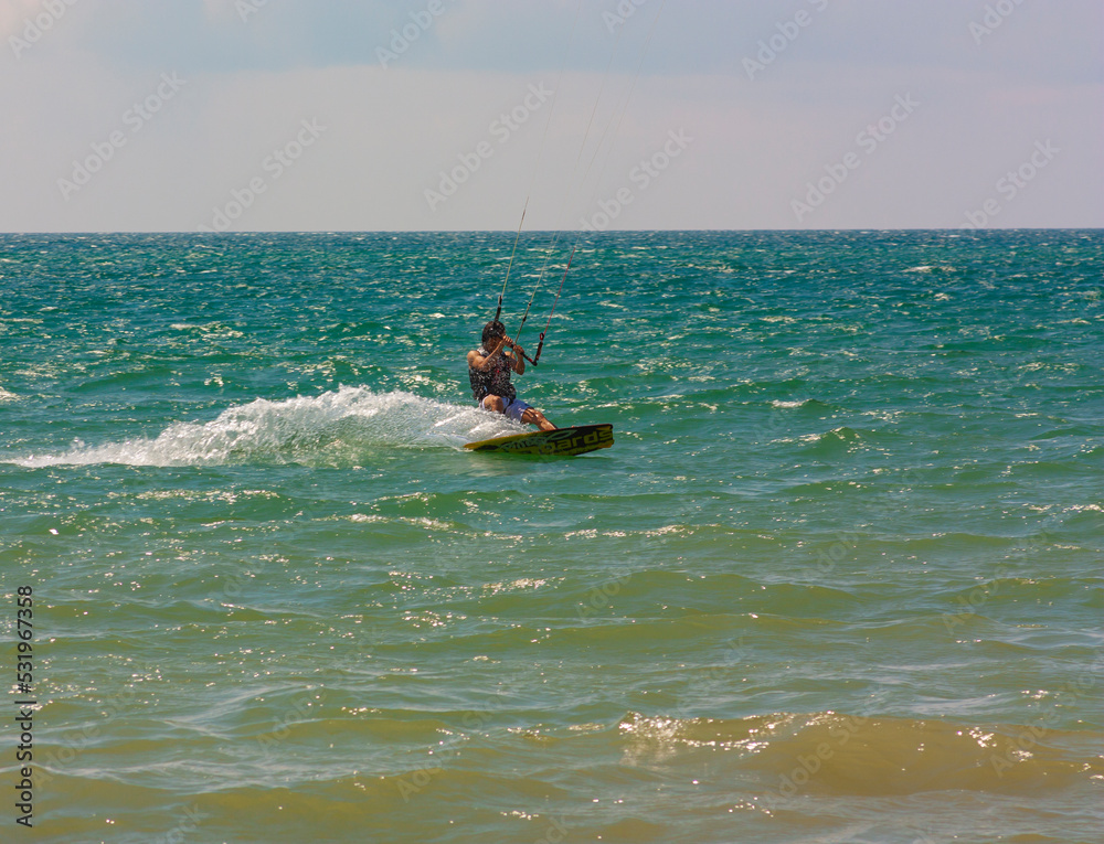 riding the kite in the sea on the waves