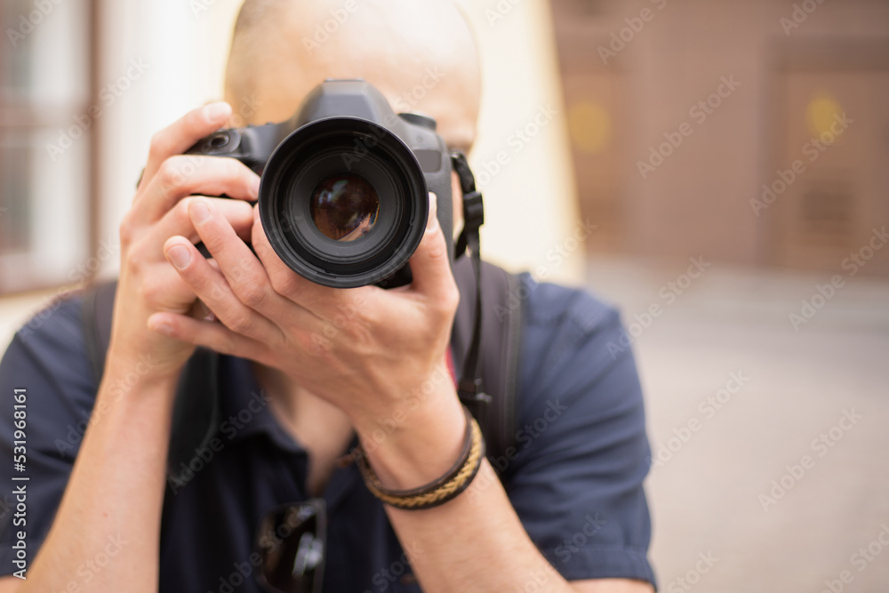 young man with a camera standing on a city street. young man with a camera standing on a city street.