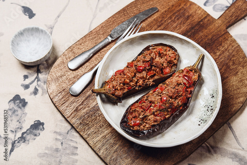 Imam bayildi. Traditional delicious Turkish food: halves of baked eggplant stuffed with vegetables on a plate. Selective focus