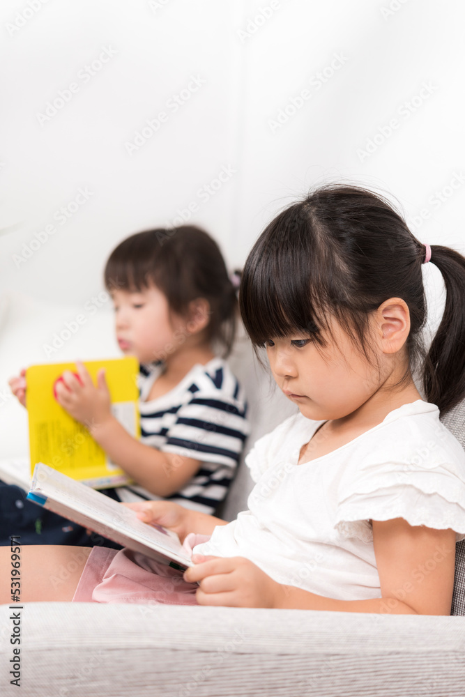 部屋で絵本を読む姉妹 部屋で絵本を読む姉妹