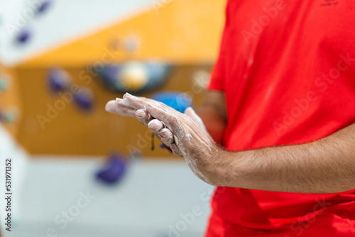 Man spreading liquid magnesium on his hands to practice climbing wall