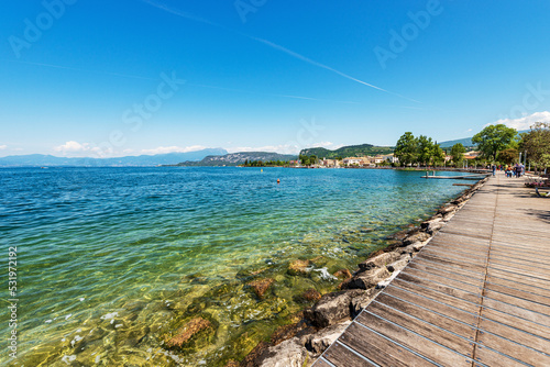 Coast of Lake (Lago di Garda) near the small town of Bardolino, tourist resort in Verona province, Veneto, Italy, southern Europe. On the left in the background the coast of Lombardy. photo
