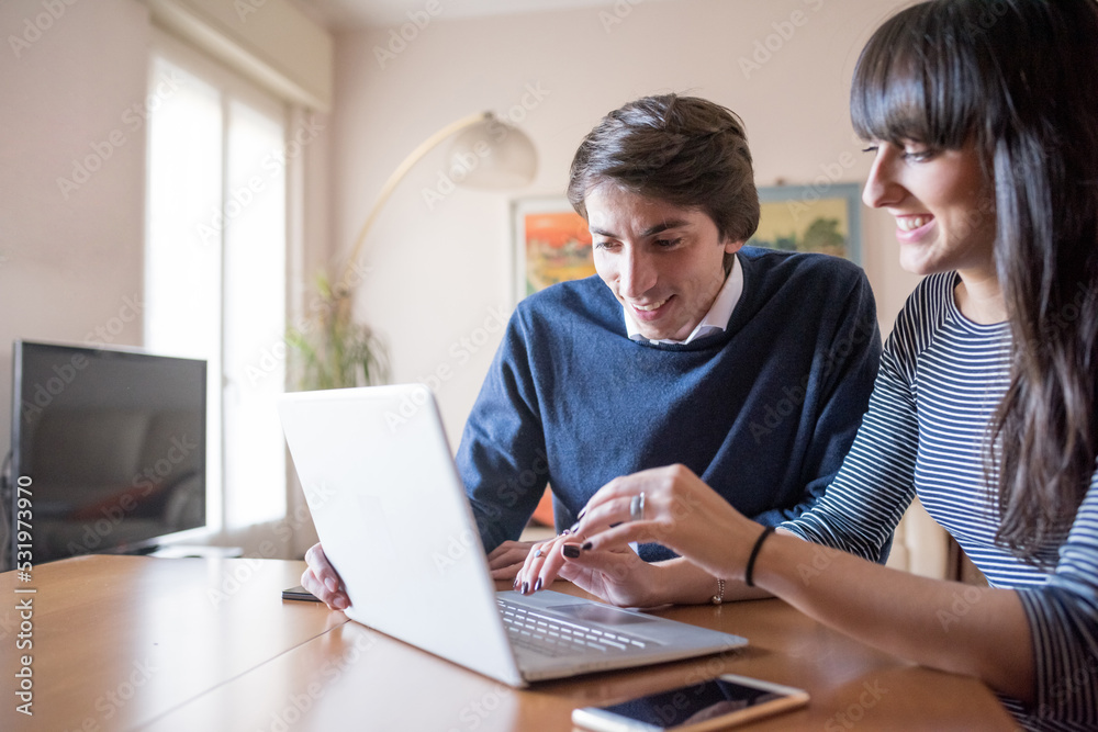 Couple man and woman indoors at home working together Couple man and woman indoors at home working together