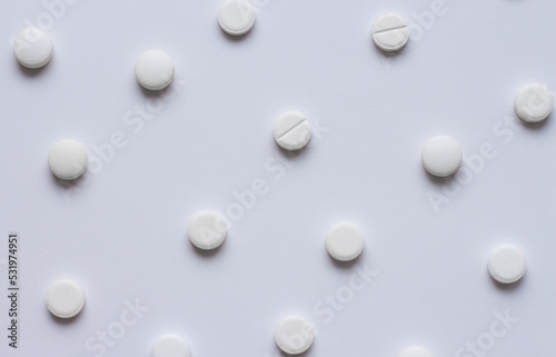 Many white tablets or pills on a white background. Medical pharmacy and medicine concept with copy space. Scattering of white round pills. High quality photo