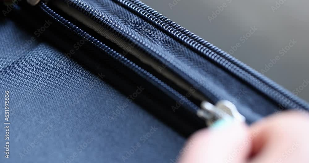Woman unzips and fastens blue suitcase or sports backpack Woman unzips and fastens blue suitcase or sports backpack