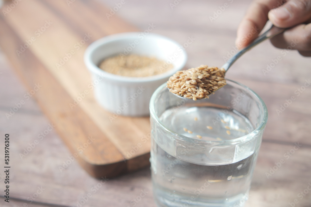 mixing flax seeds in glass of water mixing flax seeds in glass of water