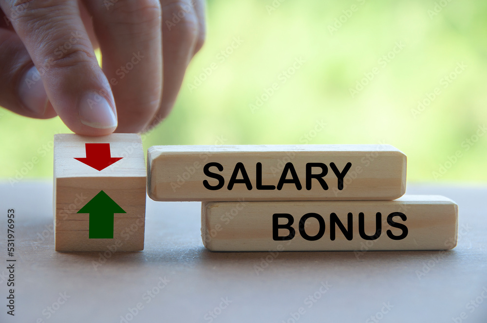 Finger turning wooden block changing the arrow direction up and down for salary and bonus. Salary and bonus increment concept Finger turning wooden block changing the arrow direction up and down for salary and bonus. Salary and bonus increment concept