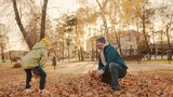 father and little child in an autumn park throw dry leaves up, happy family, live fun with dad, cheerful kid plays with foliage and parent hands throwing leaf fall, parental care of girl, nature walk.