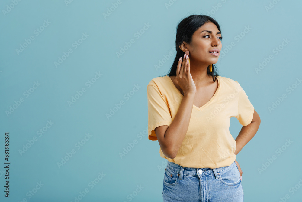 Young indian woman wearing t-shirt posing and looking aside Young indian woman wearing t-shirt posing and looking aside