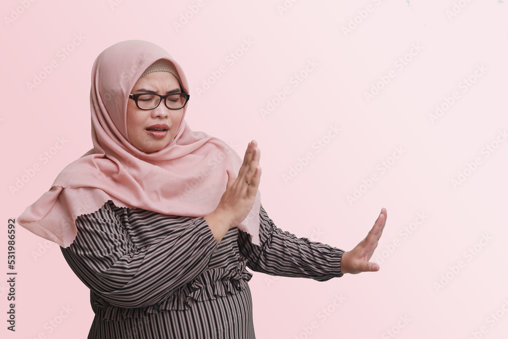 Portrait of cheerful Asian woman with hijab, forming a hand gesture to ...