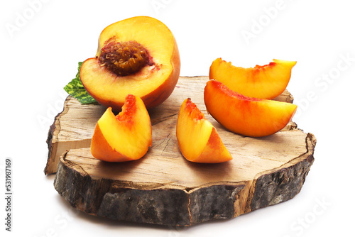 Peach slices on a wooden board and honey with a wooden spoon. Shallow depth of field