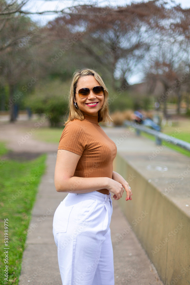Portrait of a happy and attractive Latin woman with a kind and sincere smile, in a good mood, with sunglasses looking at the camera