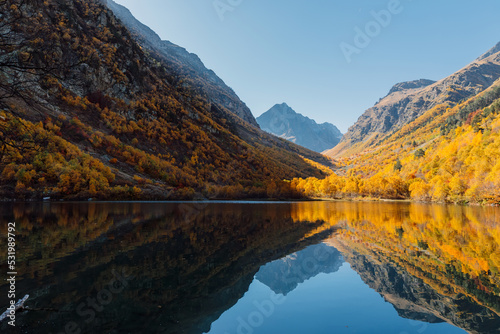 Mountain lake with glassy water and autumnal nature.