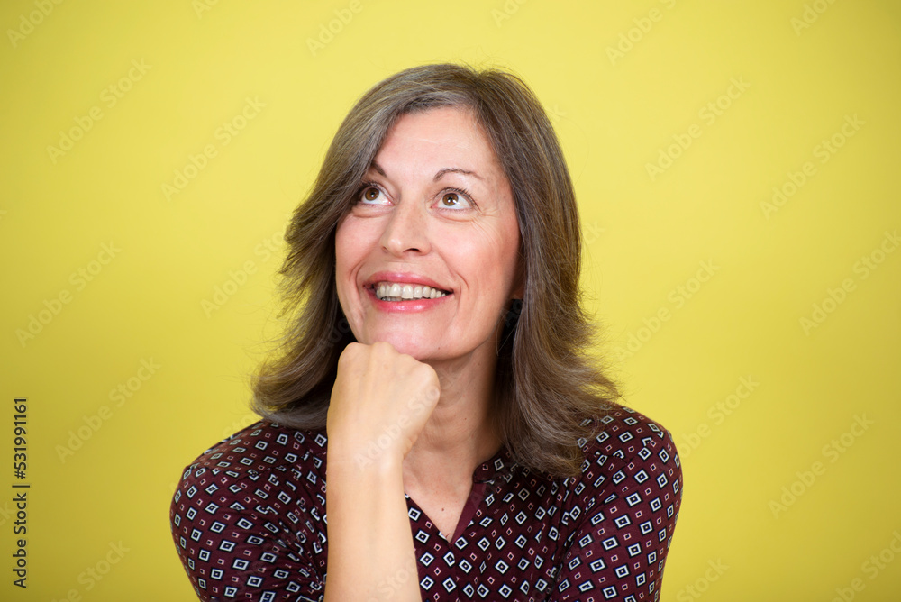 Portrait of a smiling middle-aged woman on a yellow background
Portrait of a smiling middle-aged woman on a yellow background