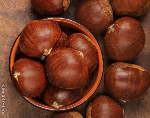 Chestnuts in a bowl on a wooden background. Autumn fall seasonal composition with horse chestnuts .