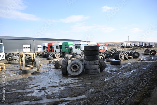 bulldozer at work site, old tires stacked to be transported to the warehouse
