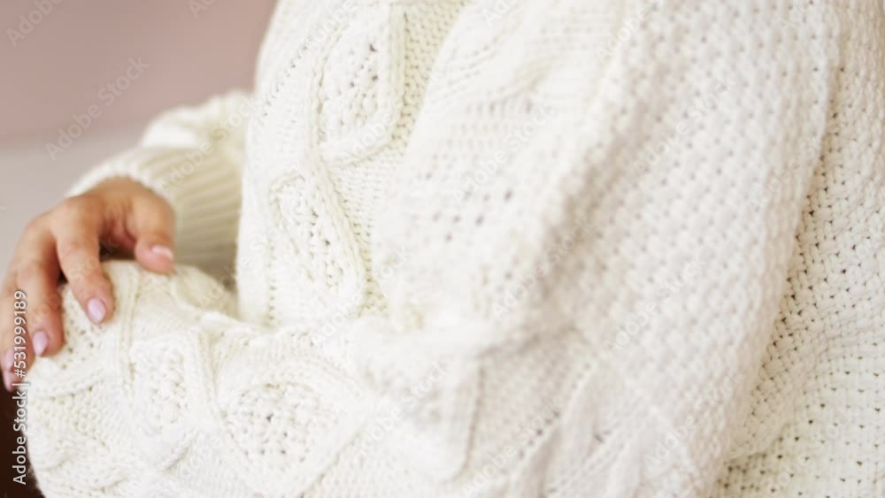 Hand touching knitted wool cloth warm fluffy white sweater. Handcraft knitting woolen fabric surface. Hand touching knitted wool cloth warm fluffy white sweater. Handcraft knitting woolen fabric surface.