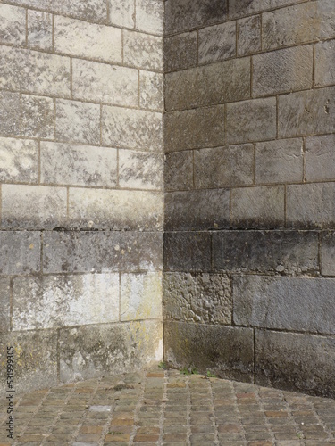 Mur de pierres d'une église. Texture et arrière-plan. Vue extérieure sur un angle et sol pavé