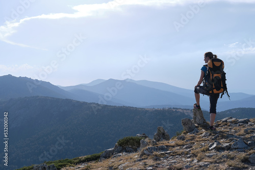 A Female traveler with backpack admiring mountains