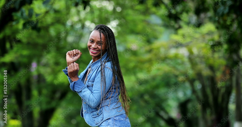 Happy African woman dancing outside in street Happy African woman dancing outside in street