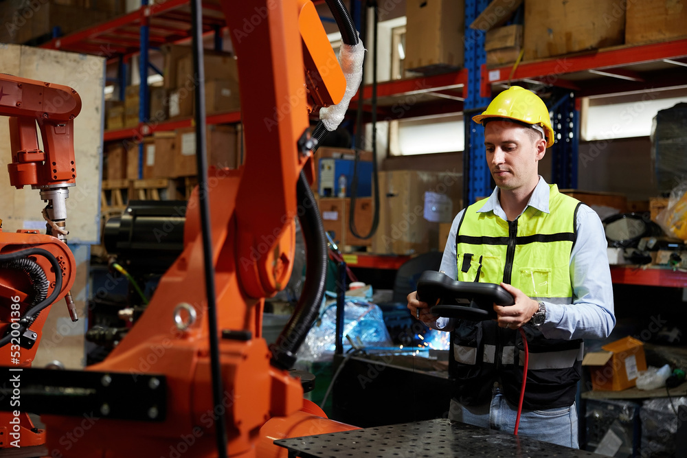 factory worker or engineer operating remote switch controller to control robot machine in the factory factory worker or engineer operating remote switch controller to control robot machine in the factory