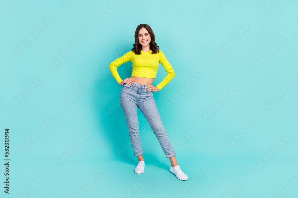 Full size photo of young pretty nice woman hands waist smiling posing after party outfit casual isolated on aquamarine color background Full size photo of young pretty nice woman hands waist smiling posing after party outfit casual isolated on aquamarine color background