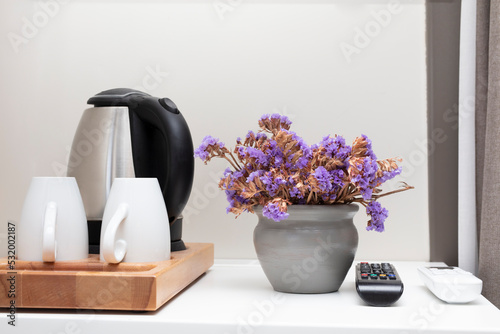 Beverage set with coffee cup, kettle, glasses, tea, coffee, sugar in hotel room