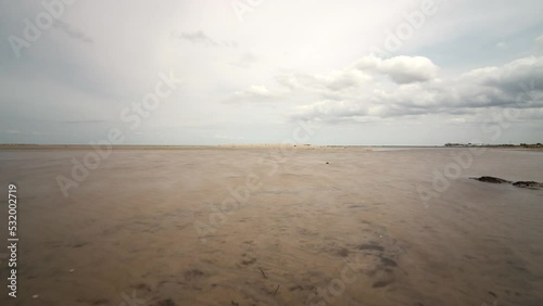 Time lapse shot of the mudflat of the protected area Grüner Brink near Puttgarden on the island Fehmarn in the Baltic Sea. Clouds travel by while the water rises and decreases