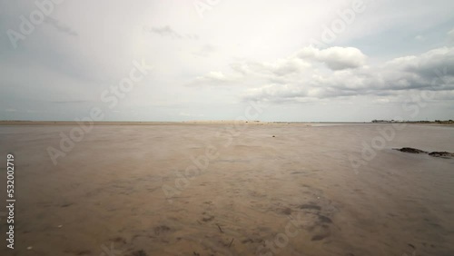 Time lapse shot of the mudflat of the protected area Grüner Brink near Puttgarden on the island Fehmarn in the Baltic Sea. Clouds travel by while the water rises and decreases photo