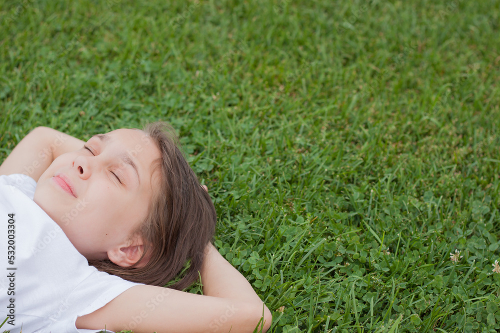 Portrait of a little girl lying on the green grass Portrait of a little girl lying on the green grass