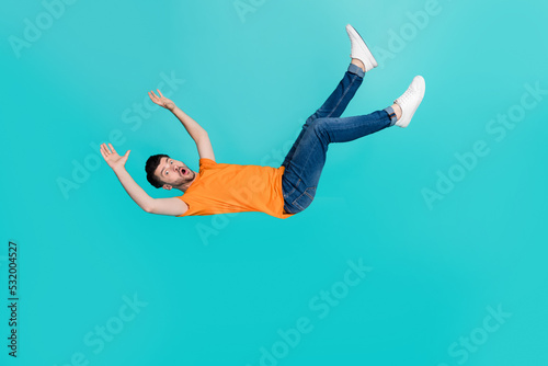 Fotografija Full size photo of frightened guy falling downward by accident isolated on cyan