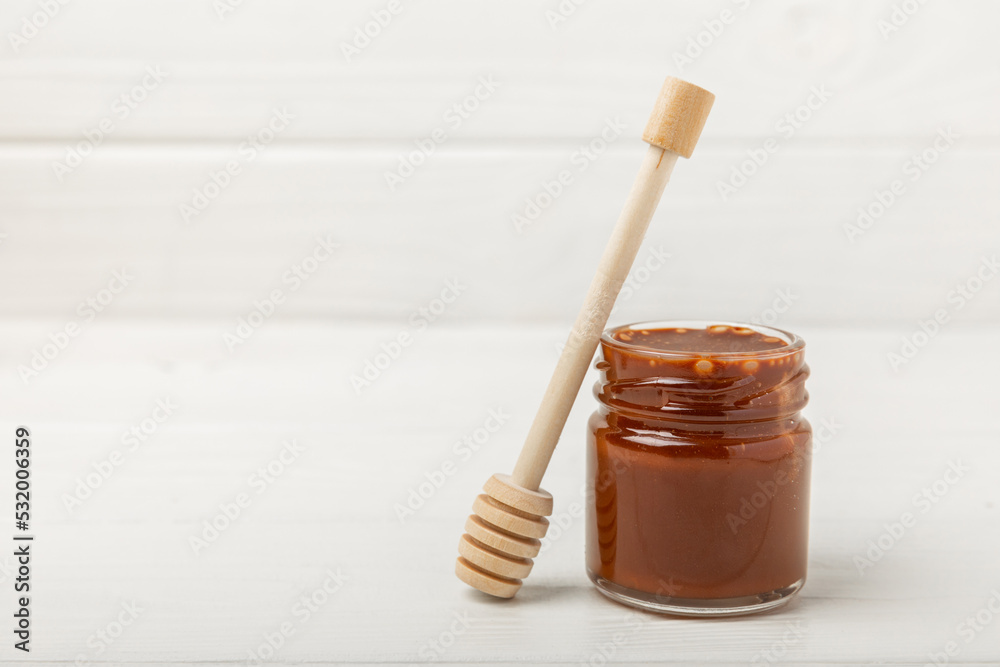 Nut honey jar on white wood. Cold medicine. Useful fortified product with almonds, pistachios, star anise and cinnamon for health and beauty. Vegetarian diet organic product. Copy space.place for text Nut honey jar on white wood. Cold medicine. Useful fortified product with almonds, pistachios, star anise and cinnamon for health and beauty. Vegetarian diet organic product. Copy space.place for text