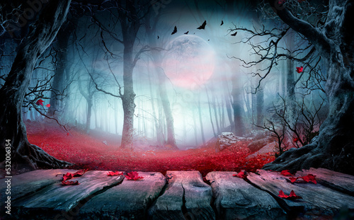 Halloween - Wooden Table In Spooky Forest At Night With Red Leaves In Autumn Landscape At Moonlight © Romolo Tavani